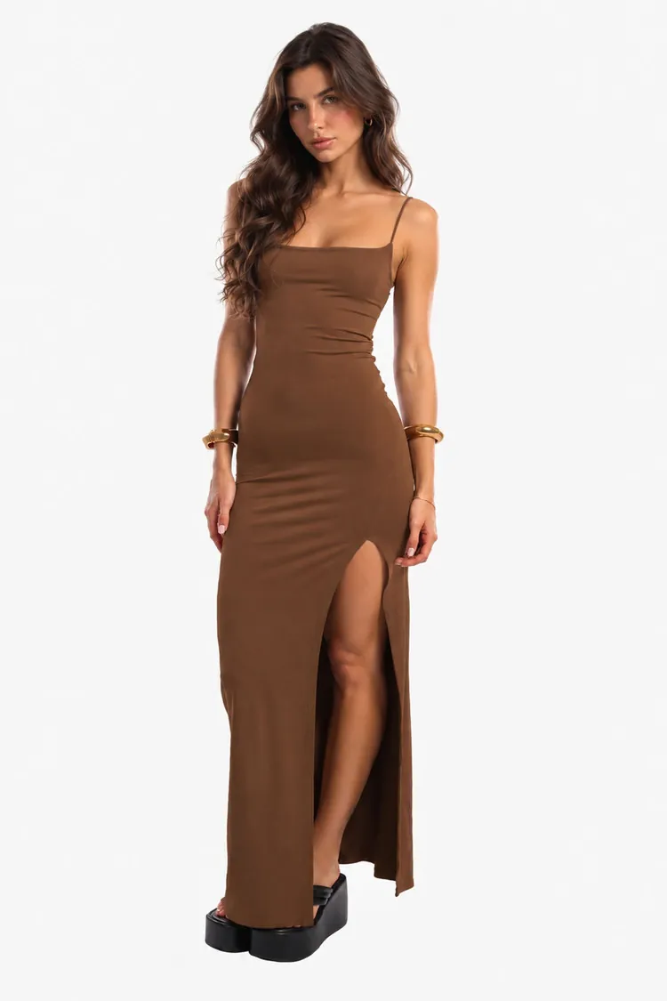 Modelo com vestido longo marrom e fenda